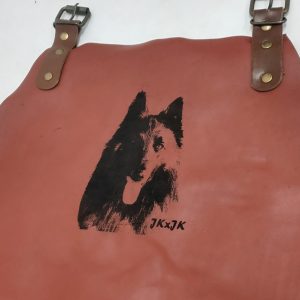 Rote Lederschürze mit graviertem Hundekopf und Initialen